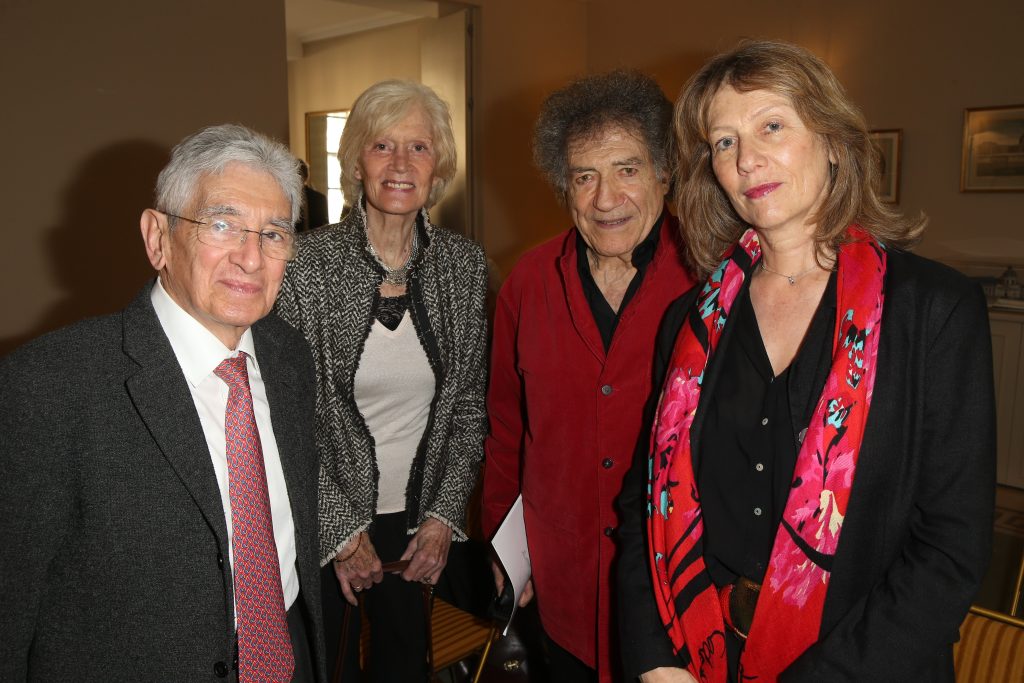 Quatre personnes posent ensemble lors d’une réception en intérieur.
