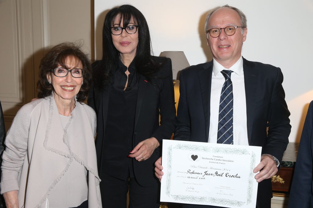 Trois personnes posent ensemble lors d’une remise de prix.