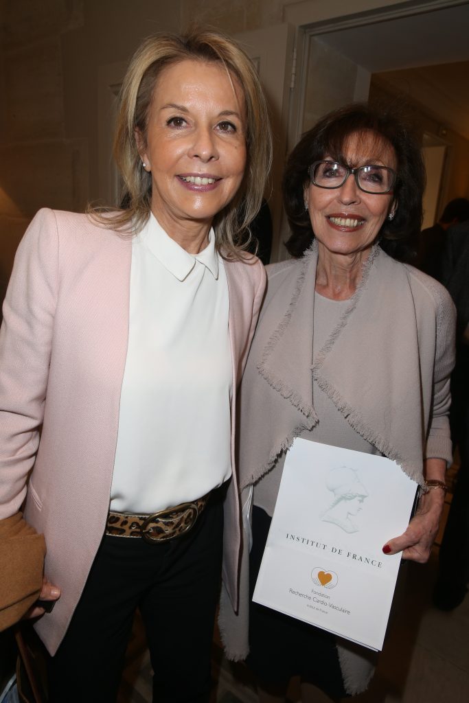 Deux femmes souriantes posent ensemble lors d’un événement officiel.
