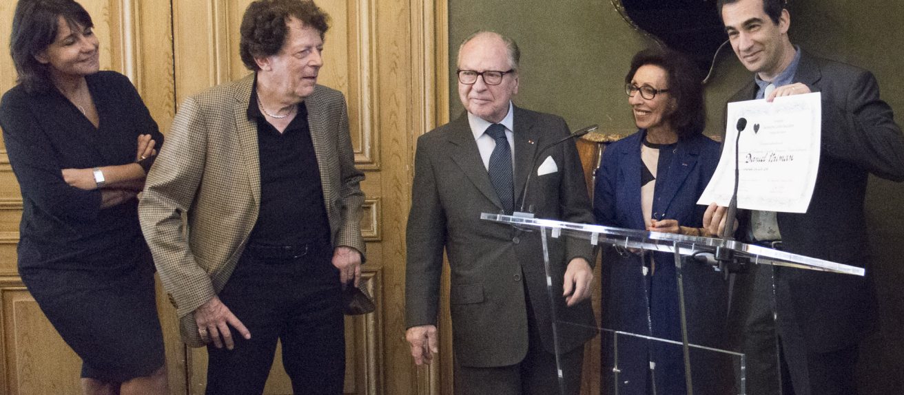 Des personnes participent à une remise officielle de document lors d’une cérémonie.