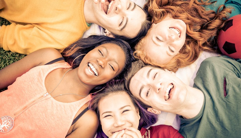 Groupe de femmes souriantes éclatant de rire dans une ambiance estivale et détendue