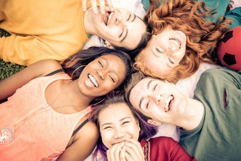 Groupe de femmes souriantes éclatant de rire dans une ambiance estivale et détendue