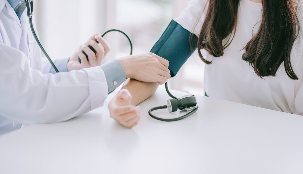 Professionnel de santé réalisant une prise de tension artérielle à une patiente
