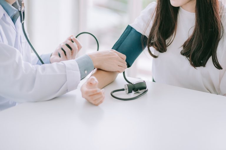 Professionnel de santé réalisant une prise de tension artérielle à une patiente