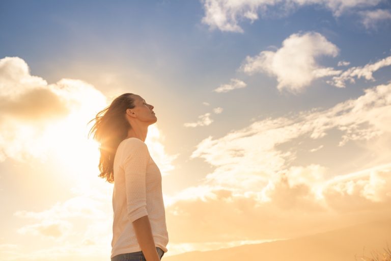 Femme sereine observant un coucher de soleil estival lors d’un épisode de forte chaleur