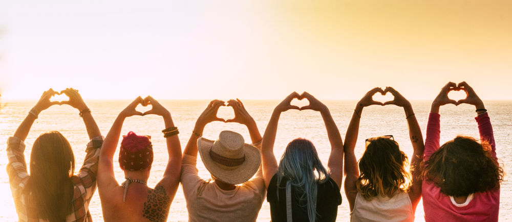 Groupe de femmes levant les bras vers le ciel et formant des cœurs avec leurs mains en symbole de solidarité et de prévention cardiovasculaire