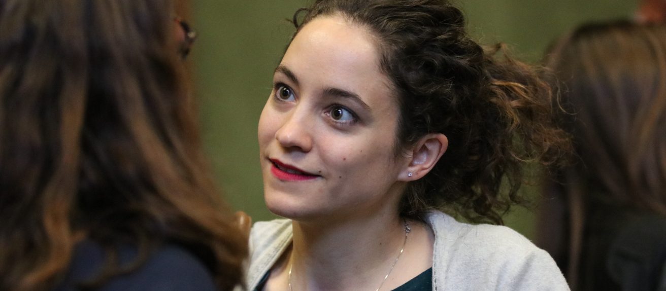Une jeune femme écoute attentivement une personne lors d’une discussion.