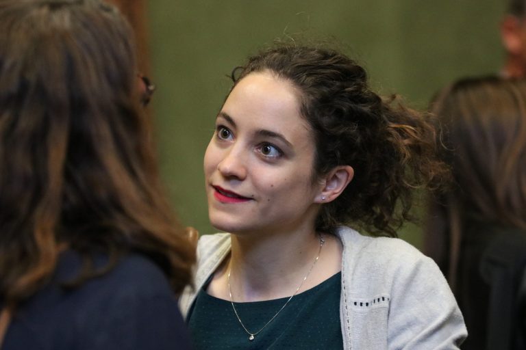 Une jeune femme écoute attentivement une personne lors d’une discussion.