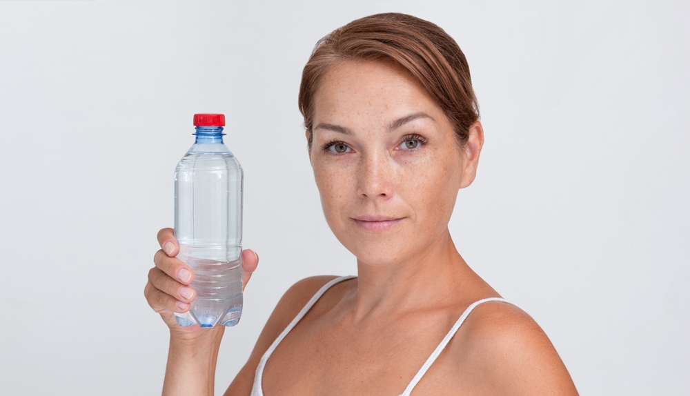 Femme buvant de l’eau pour illustrer l’hyponatrémie et les troubles de l’équilibre hydrique liés aux maladies cardiovasculaires