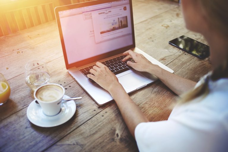 Personne travaillant sur un ordinateur portable dans un café.