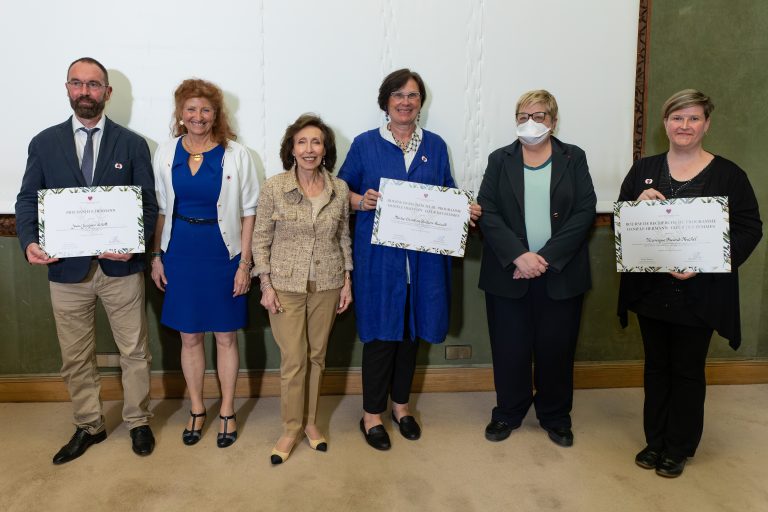 Six personnes posent ensemble lors d’une remise de distinctions avec des certificats.