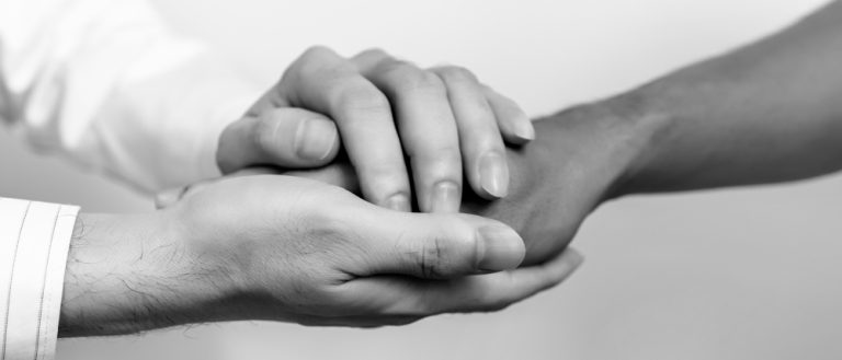Deux personnes se tenant les mains pour symboliser le soutien, l’accompagnement et l’empathie dans le domaine de la santé.