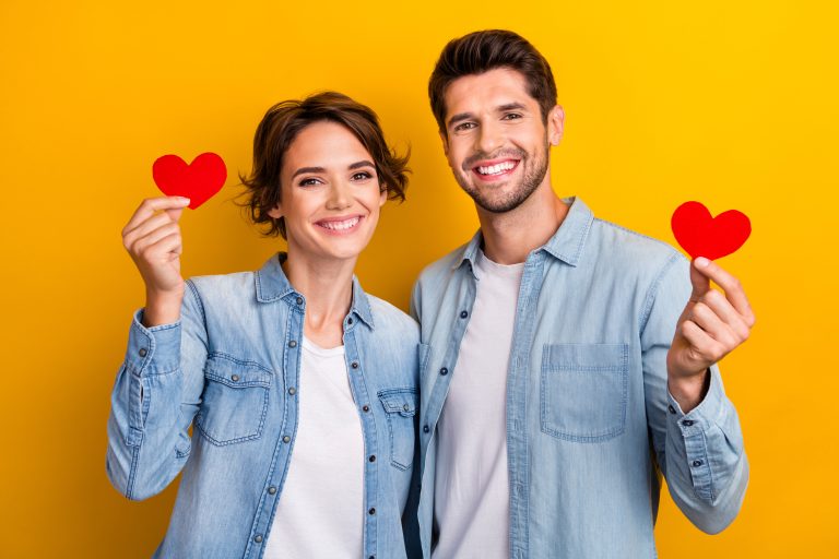 Homme et femme heureux tenant un cœur symbolisant l’amour, le bien-être émotionnel et la santé cardiovasculaire