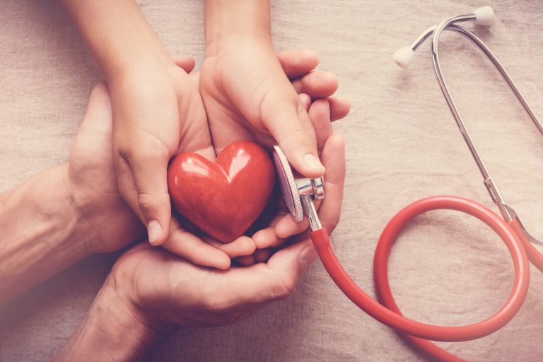 Quatre mains tenant un petit cœur symbolique pour représenter la solidarité, la prévention et la recherche contre les maladies cardiovasculaires