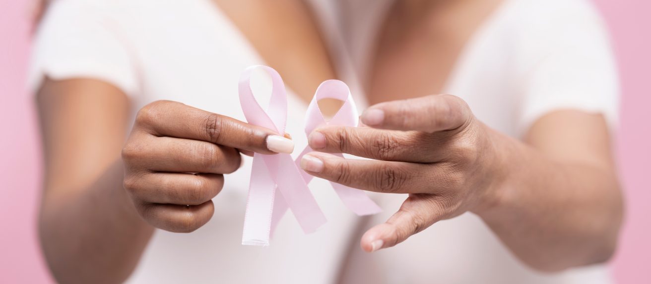 Deux femmes tenant des rubans roses pour sensibiliser au cancer du sein, à l’immunothérapie et aux risques cardiovasculaires associés aux traitements
