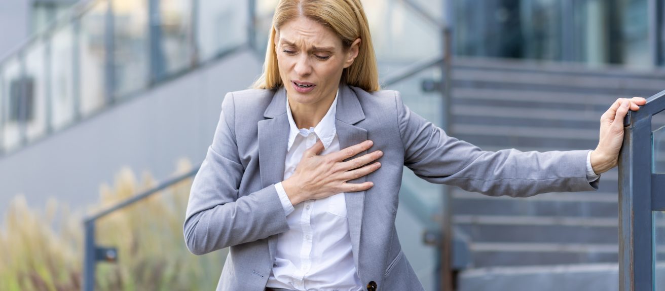 Femme se tenant la poitrine illustrant les symptômes des cardiomyopathies et troubles du muscle cardiaque.