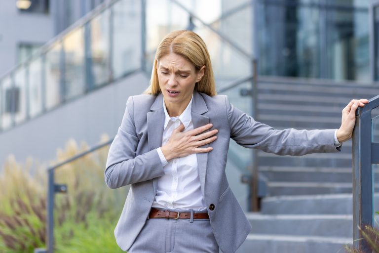 Femme se tenant la poitrine illustrant les symptômes des cardiomyopathies et troubles du muscle cardiaque.