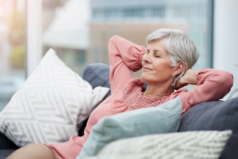 Femme se reposant sur un canapé illustrant la période de récupération après une opération cardiaque