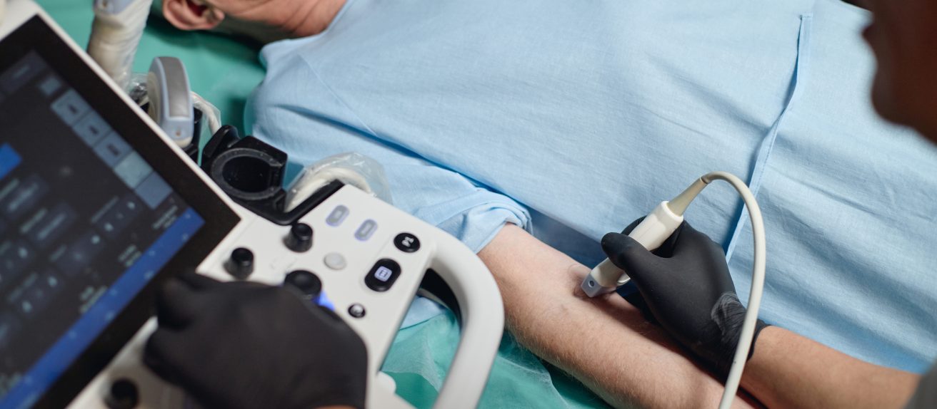 Médecin réalisant un écho-Doppler des artères avec une sonde d’échographie