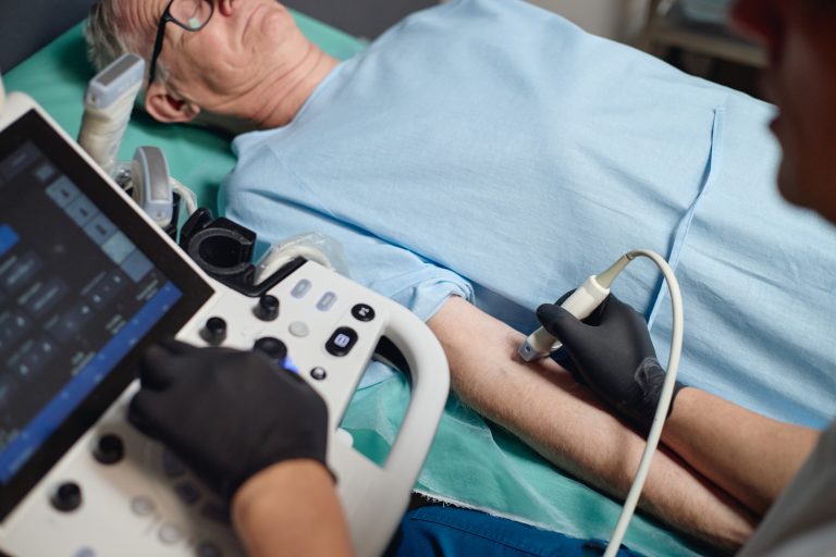 Médecin réalisant un écho-Doppler des artères avec une sonde d’échographie