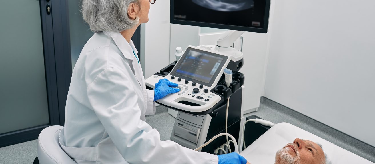 Médecin réalisant une échographie cardiaque transthoracique avec une sonde sur la poitrine d’un patient
