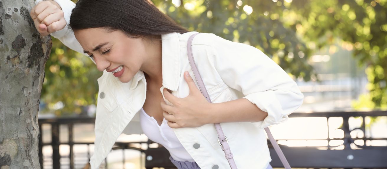 Femme tenant sa poitrine illustrant un infarctus du myocarde ou crise cardiaque.