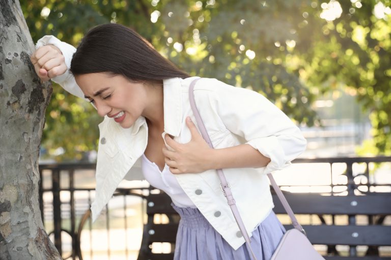 Femme tenant sa poitrine illustrant un infarctus du myocarde ou crise cardiaque.