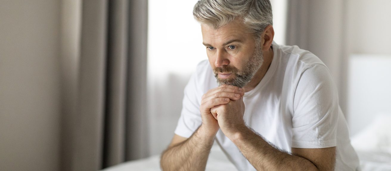 Homme prenant son temps le matin assis sur le bord du lit illustrant la gestion de l’insuffisance cardiaque au quotidien