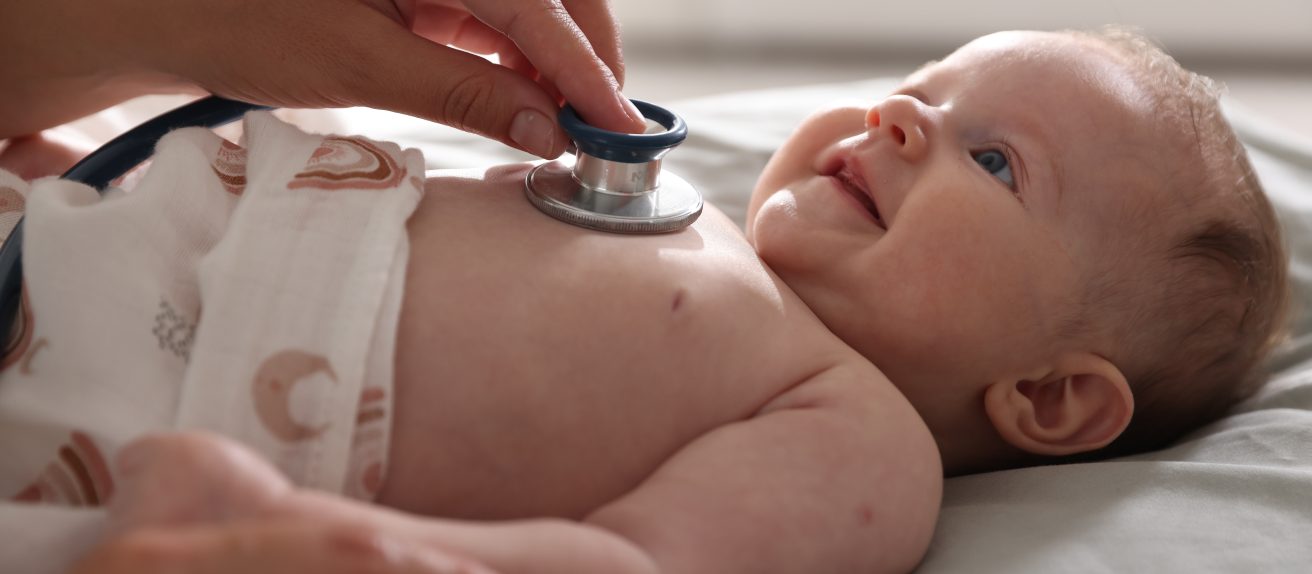 Bébé avec un stéthoscope illustrant le dépistage des malformations cardiaques congénitales.