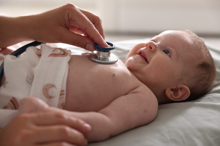 Bébé avec un stéthoscope illustrant le dépistage des malformations cardiaques congénitales.
