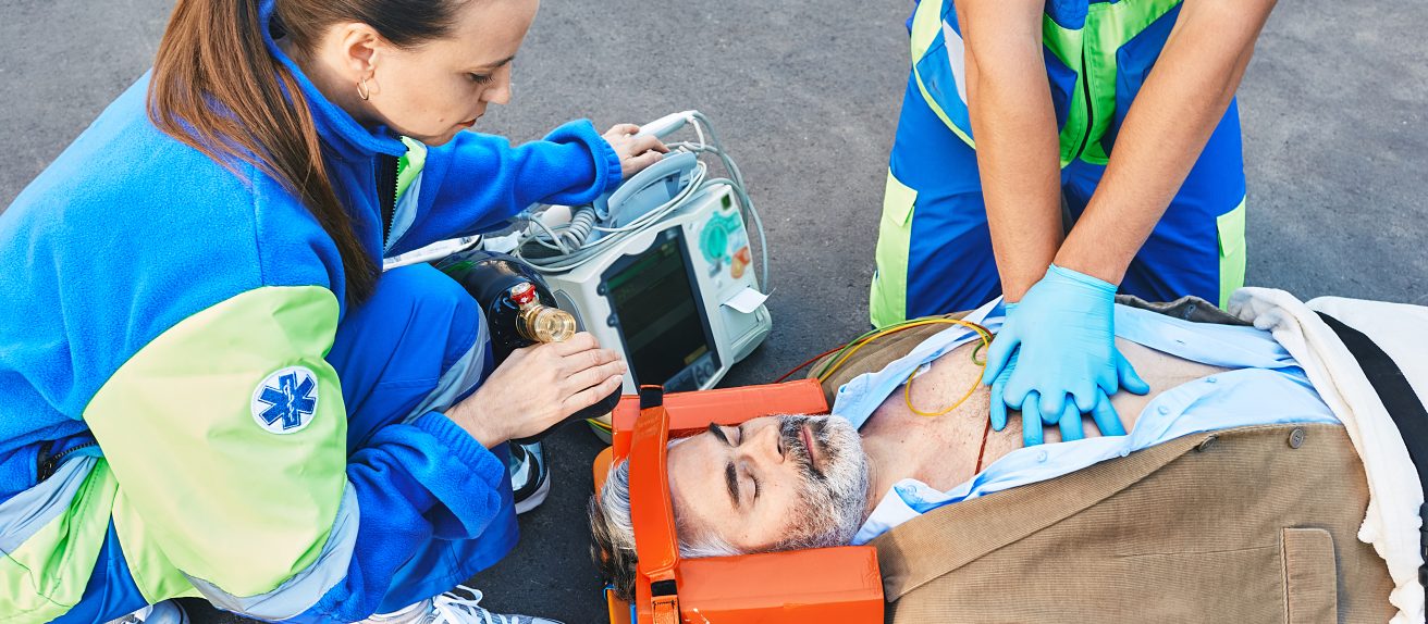 Des secouristes réalisent une prise en charge d’urgence sur un homme allongé au sol.