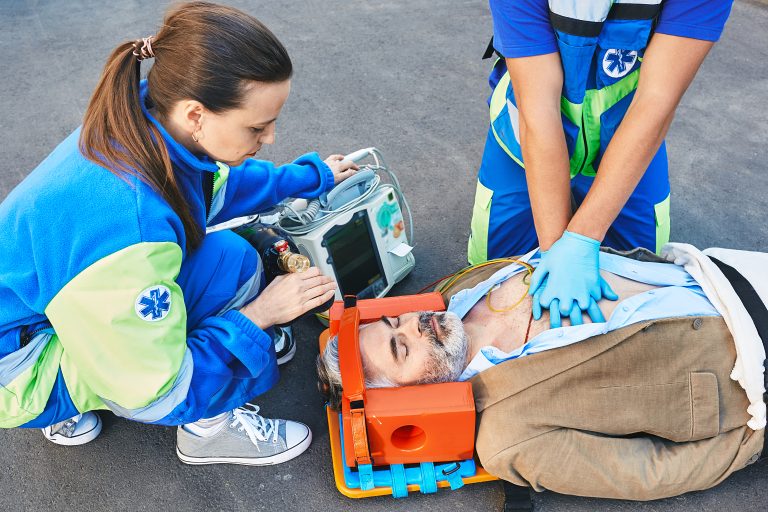 Des secouristes réalisent une prise en charge d’urgence sur un homme allongé au sol.