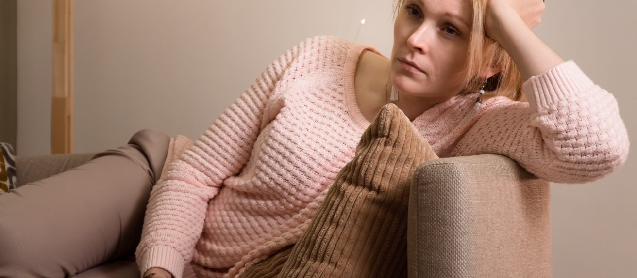 Femme assise sur un canapé illustrant les effets de la sédentarité sur la santé cardiovasculaire