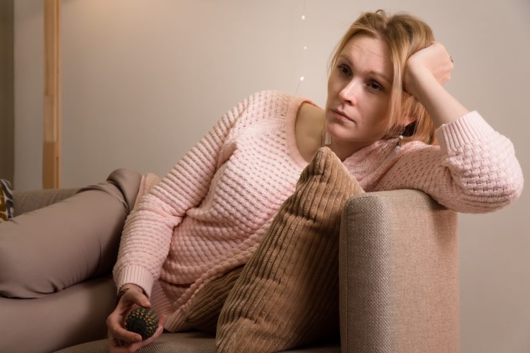 Femme assise sur un canapé illustrant les effets de la sédentarité sur la santé cardiovasculaire