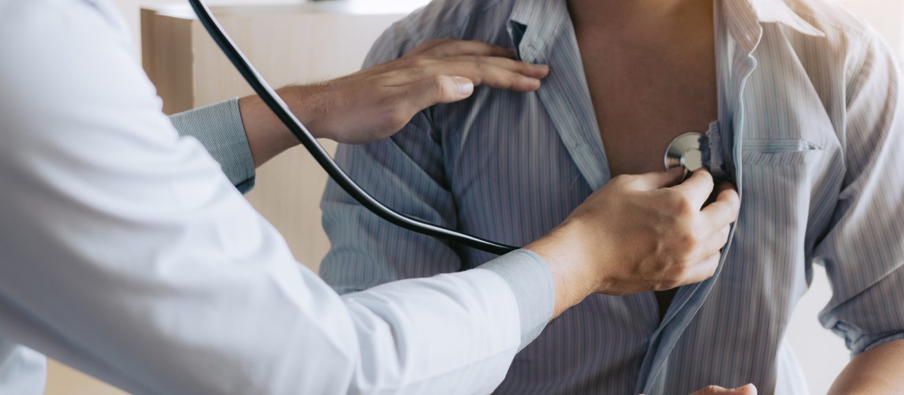 Médecin utilisant un stéthoscope pour examiner un patient, illustrant le diagnostic des valvulopathies cardiaques.