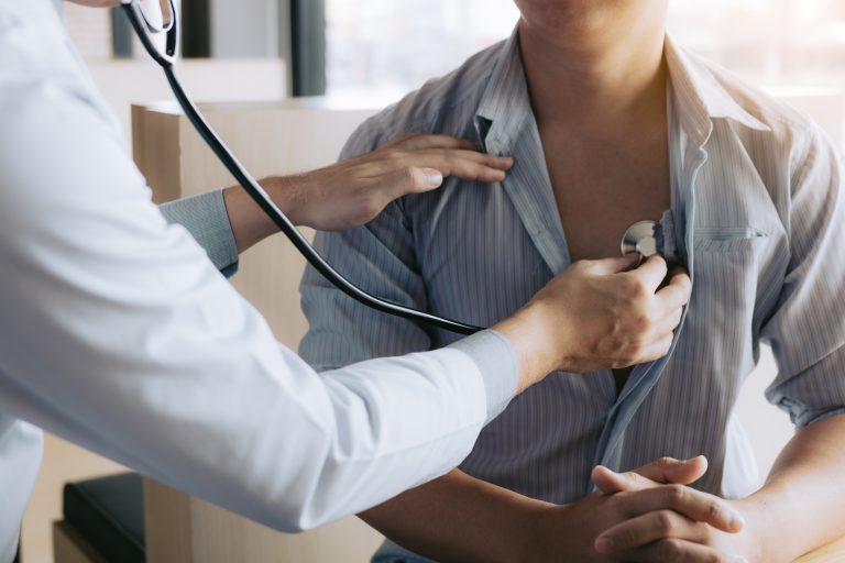 Médecin utilisant un stéthoscope pour examiner un patient, illustrant le diagnostic des valvulopathies cardiaques.