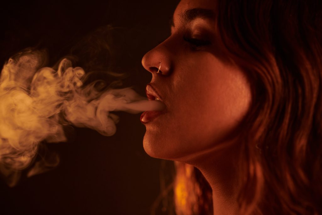 Une femme fumant une cigarette illustrant les dangers du tabac pour la santé cardiovasculaire