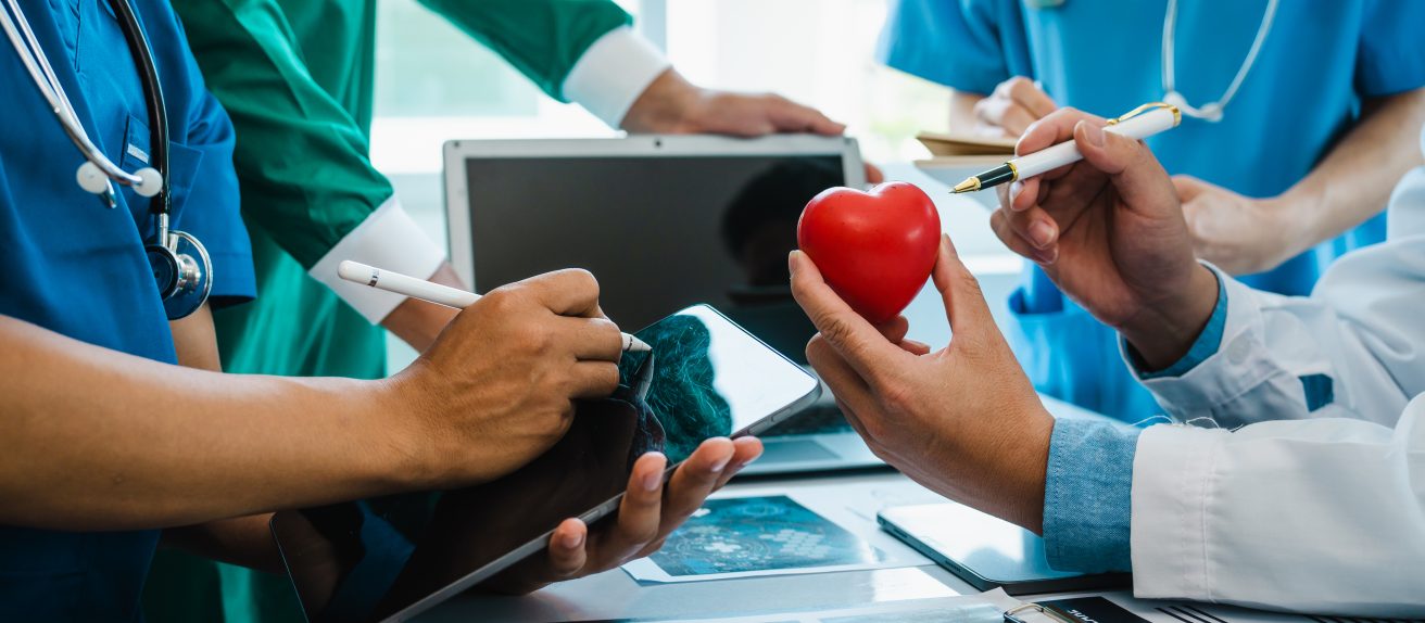 Équipe de chercheurs étudiant un modèle de cœur symbolisant la médecine cardiovasculaire du futur