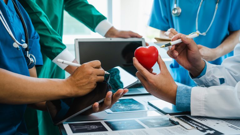 Équipe de chercheurs étudiant un modèle de cœur symbolisant la médecine cardiovasculaire du futur