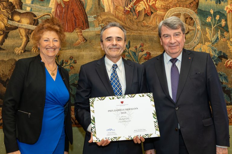 Photo de groupe lors d’un événement officiel réunissant quatre professionnels dans un espace de réception institutionnel.
