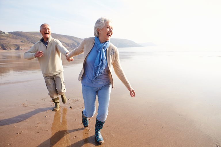 Couple de seniors heureux se promenant ensemble pour illustrer les bienfaits de l’amour, du lien social et de l’activité physique sur la santé cardiovasculaire