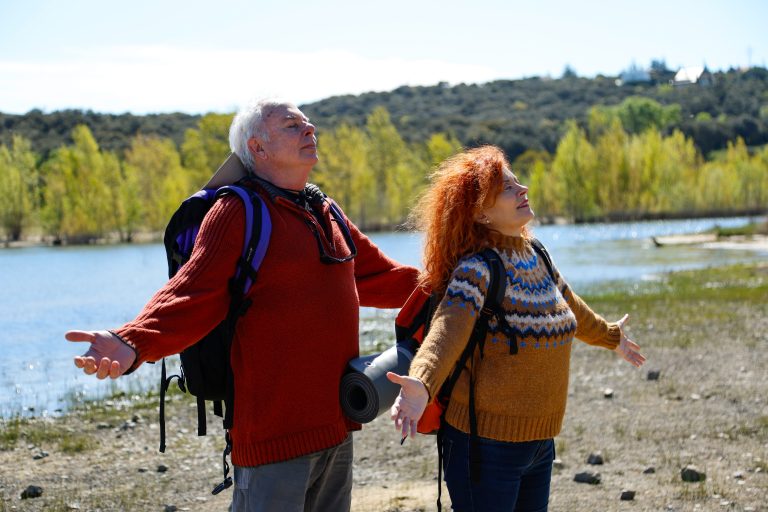 Couple de seniors profitant d’une promenade en montagne enneigée pour illustrer les bienfaits de la nature et de l’activité physique sur la santé cardiovasculaire