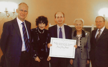 Cinq personnes posent ensemble lors d’une cérémonie avec certificat officiel.