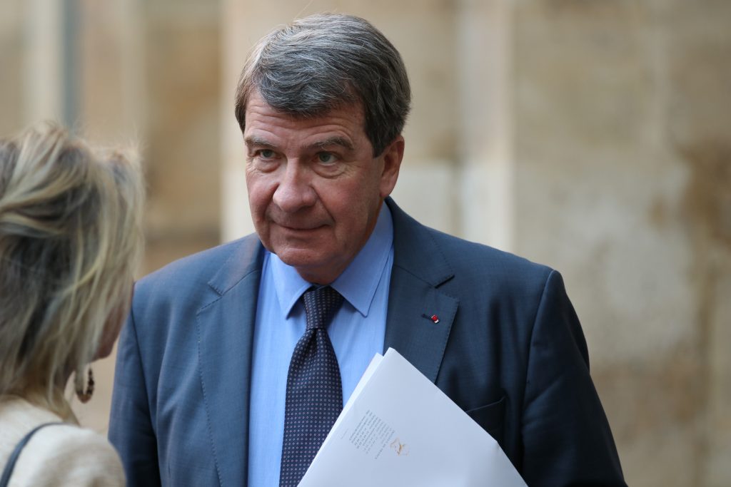 Un homme en costume discute avec une personne lors d’un événement officiel.